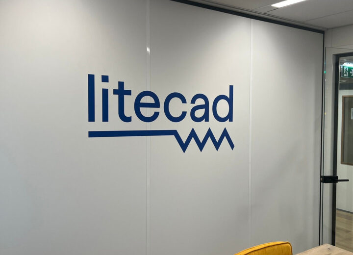 Blauw Litecad-bedrijfslogo als grote muursticker op de wand van een vergaderruimte