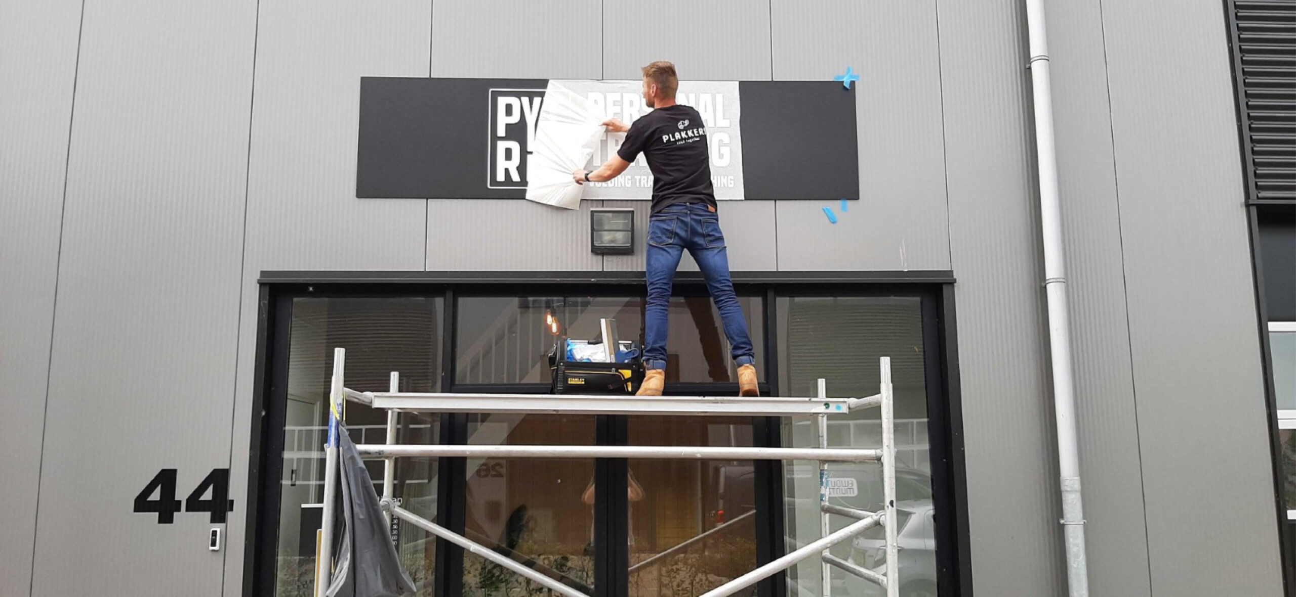 Reclamebord laten maken en professioneel aanbrengen op een bedrijfsgevel