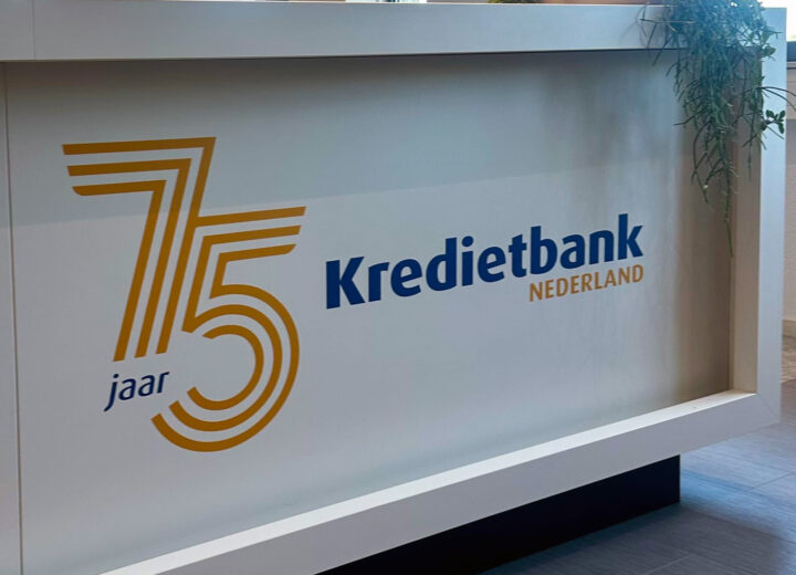 Jubileumstickers met logo van Kredietbank Nederland op een witte ontvangstbalie