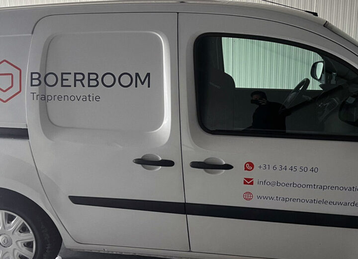 Witte bedrijfsbus van Boerboom Traprenovatie met logo en contactgegevens op de zijkant