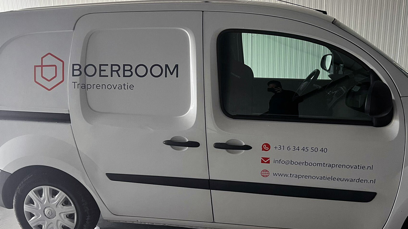 Witte bedrijfsbus van Boerboom Traprenovatie met logo en contactgegevens op de zijkant