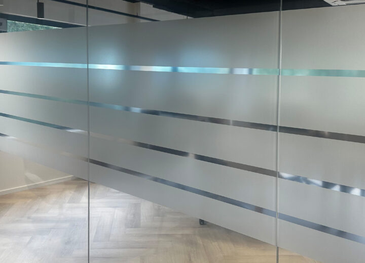 Brede matte privacyfolie met transparante strepen op een glazen wand bij Arbocentrum Ede
