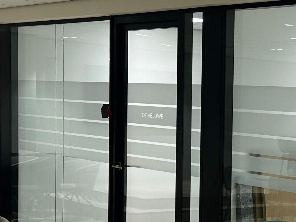 Glazen kantoorwand met matte privacyfolie en transparante strepen bij Arbocentrum in Ede