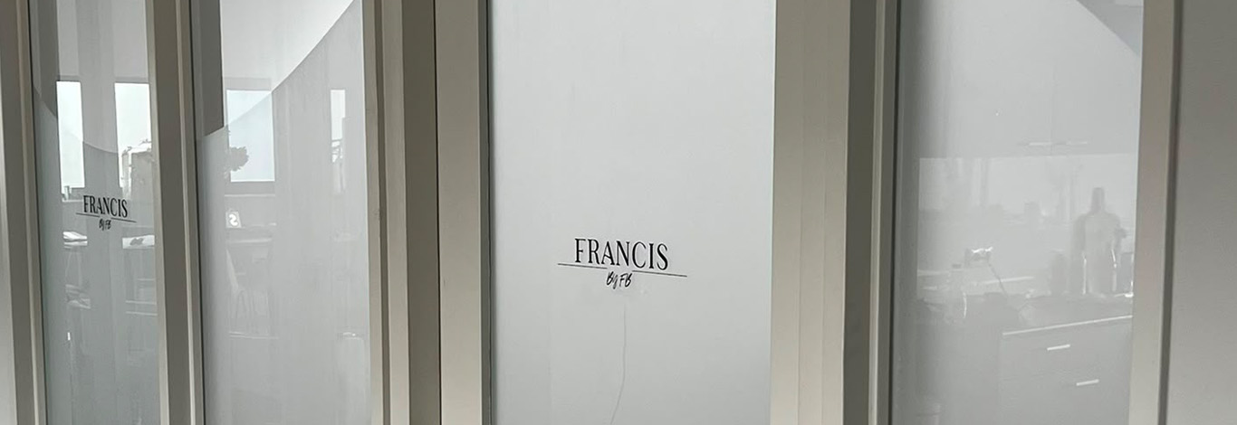 Langwerpig overzicht van privacyfolie met golvend patroon en zwart FRANCIS-logo op glazen kantoorwanden